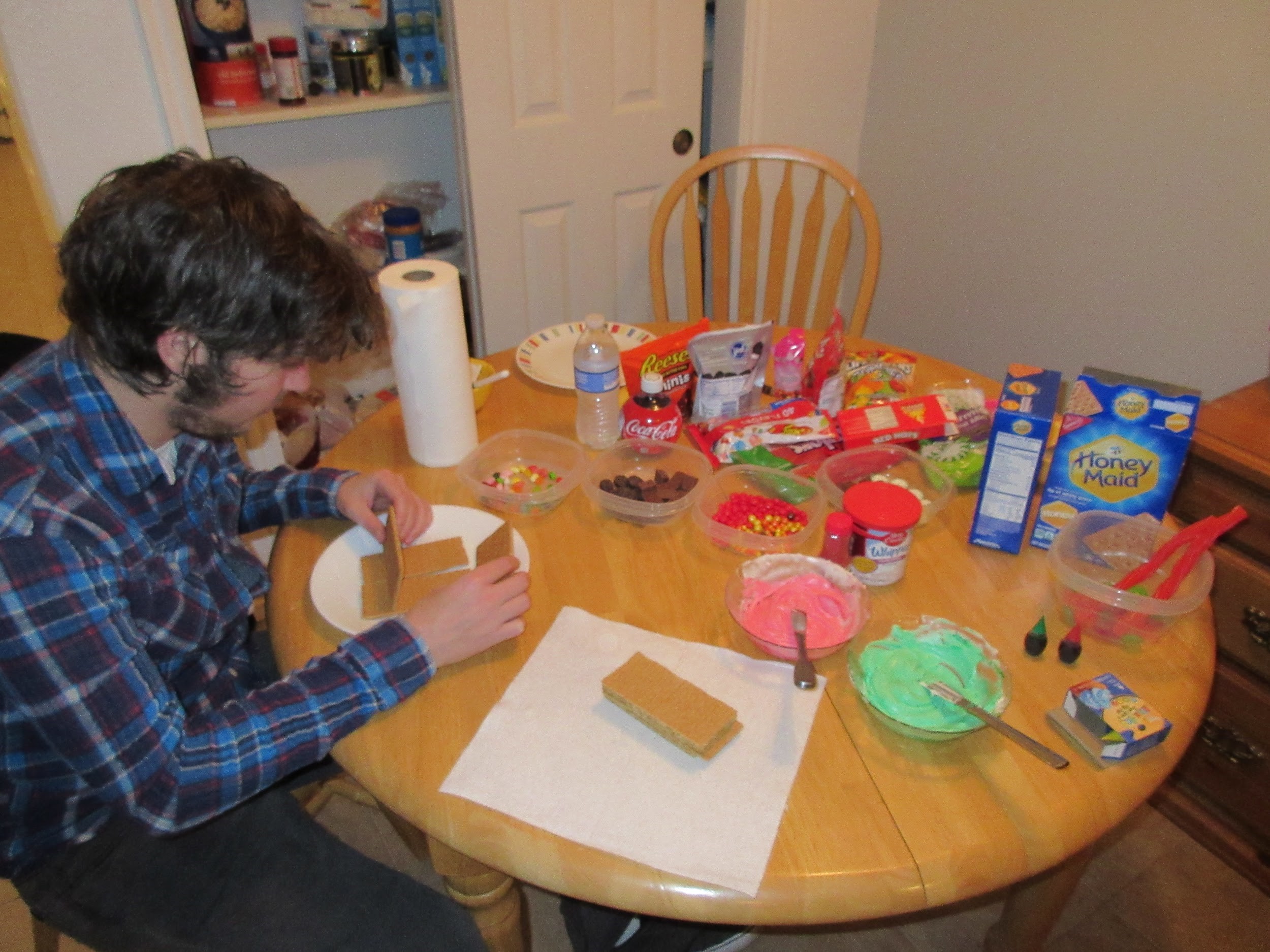 Taylor making graham cracker gingerbread houses