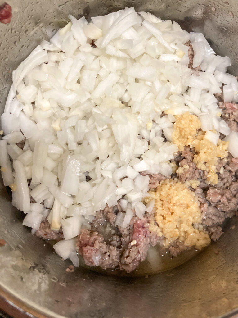 Onions, garlic, and sausage browning in the Instant Pot