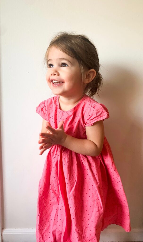 Toddler in pink Three Little Peas dress