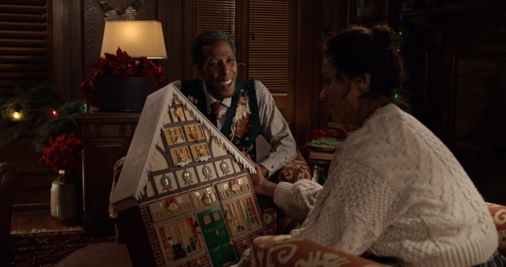 A grandfather presents his black granddaughter with a holiday advent calendar