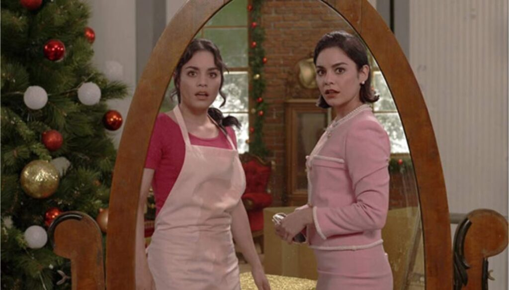 Two girls who look exactly alike stare at their reflection in a large mirror together in the holiday chick flick The Princess Switch, starring Vanessa Hudgens