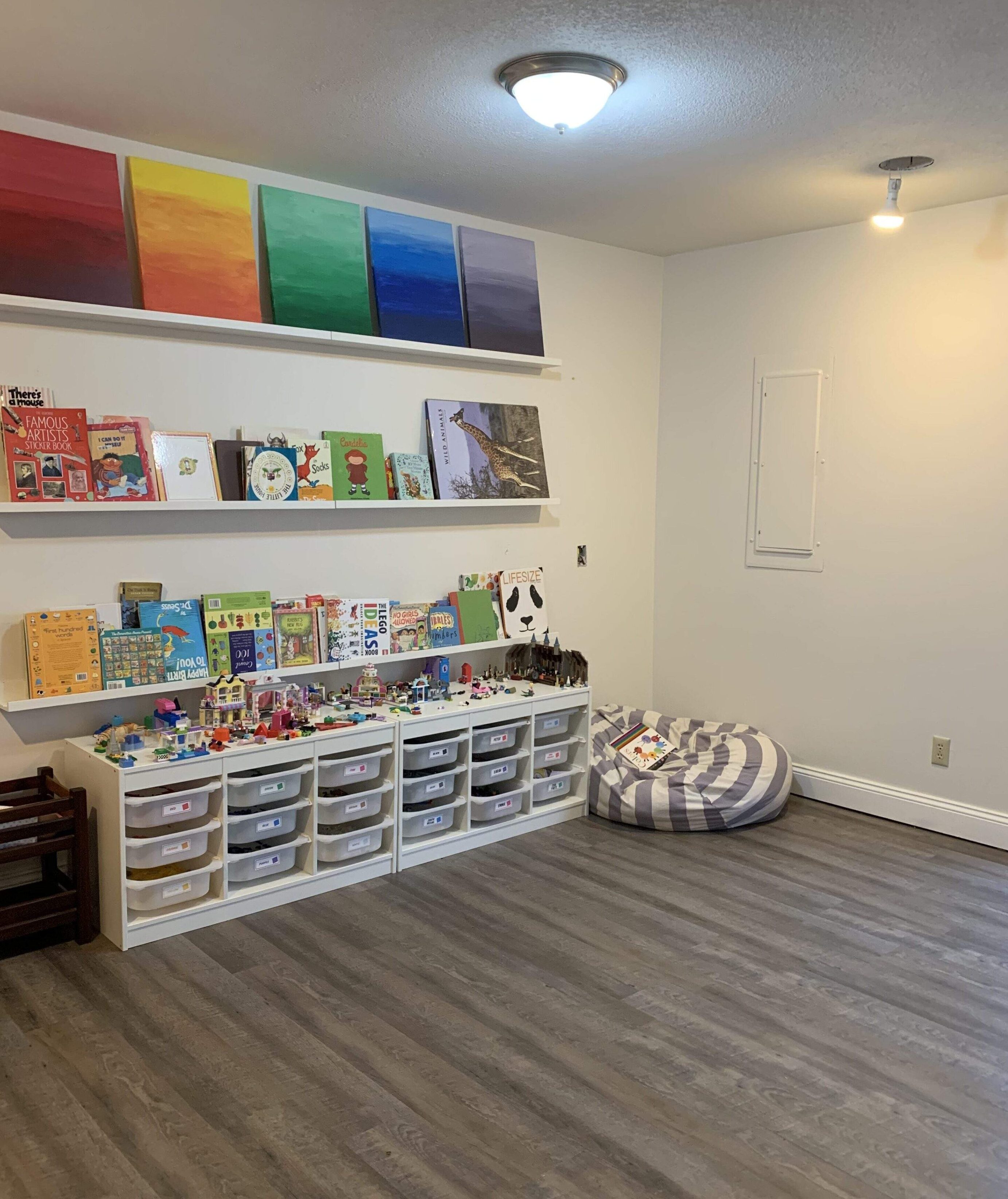 homeschool room with paintings, books, and lego storage